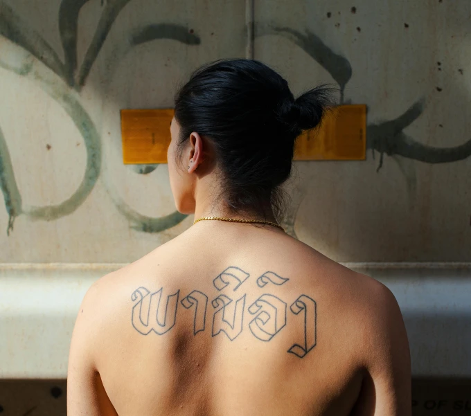 an indian woman with a back tattoo on her chest