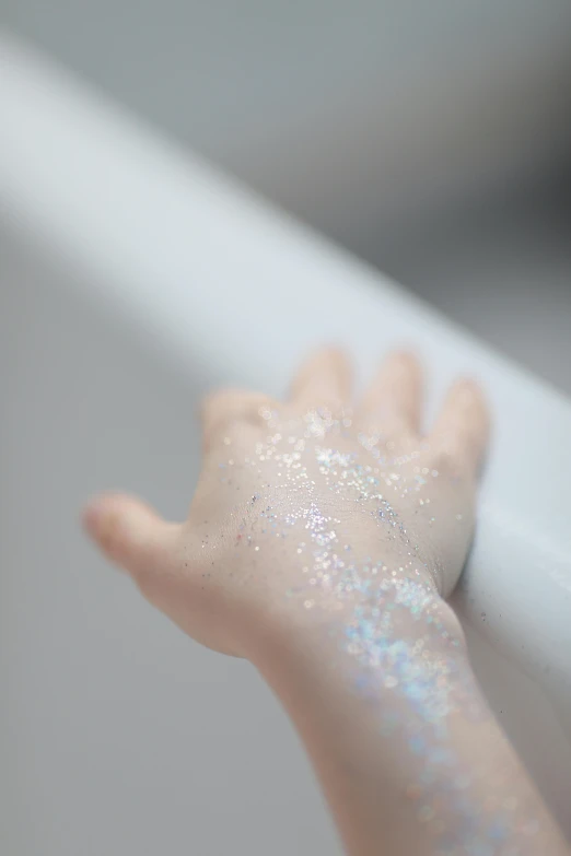 the hand of a baby is covered in glitter