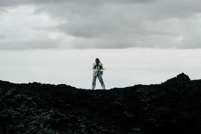 a person on a hill next to the clouds