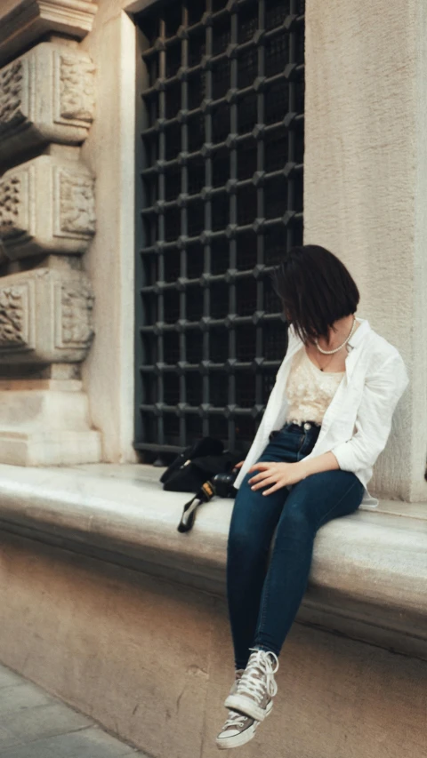 a woman sitting on the ledge of an old building