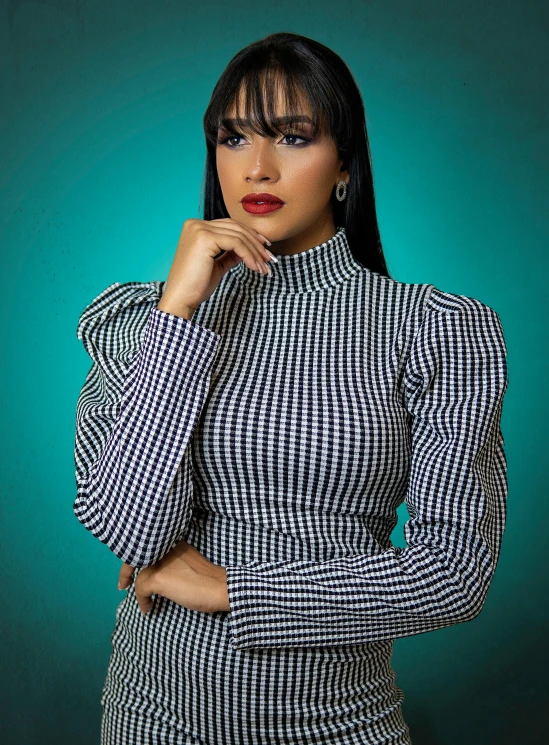 the woman wearing a checkered suit and earrings poses for the camera