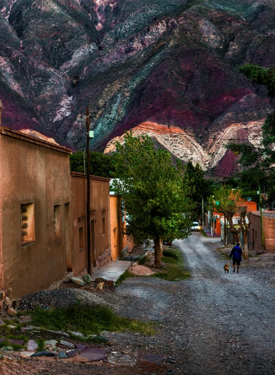 a man walking down a street next to some buildings