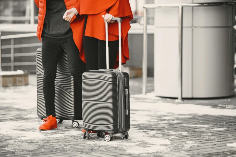 two women carrying suitcases in winter clothes