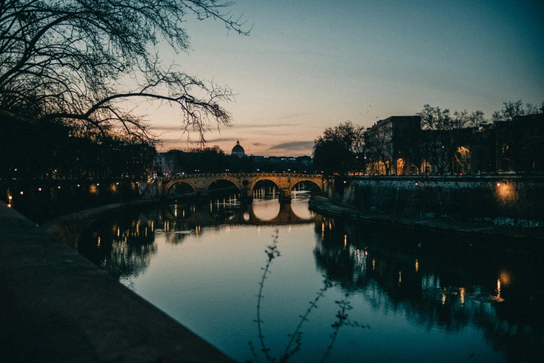 a view of a river next to an old stone bridge