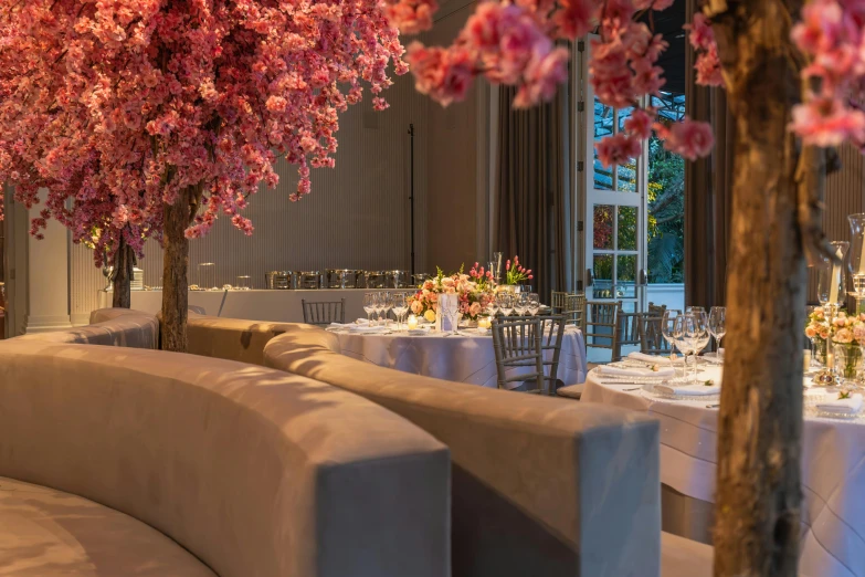 a dining room table with a white bench and flower arrangement