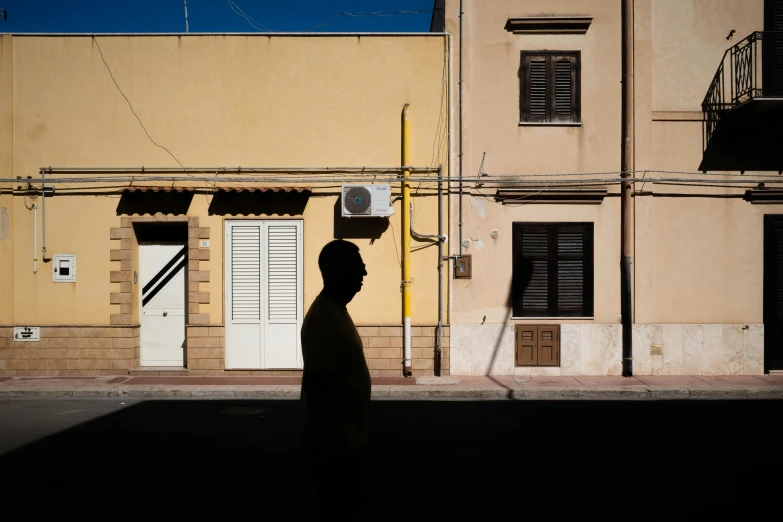 a man is walking past an apartment building