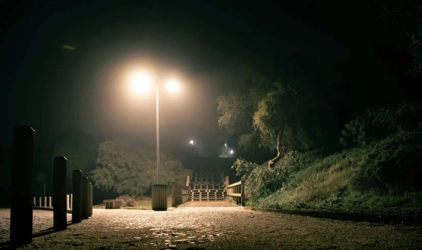 a street light shines off on a dark night