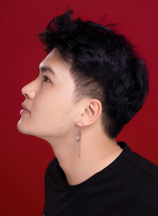 a male with black hair and piercings is looking into the distance