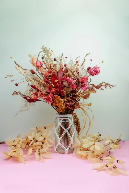 a vase of fall flowers in front of a blue wall