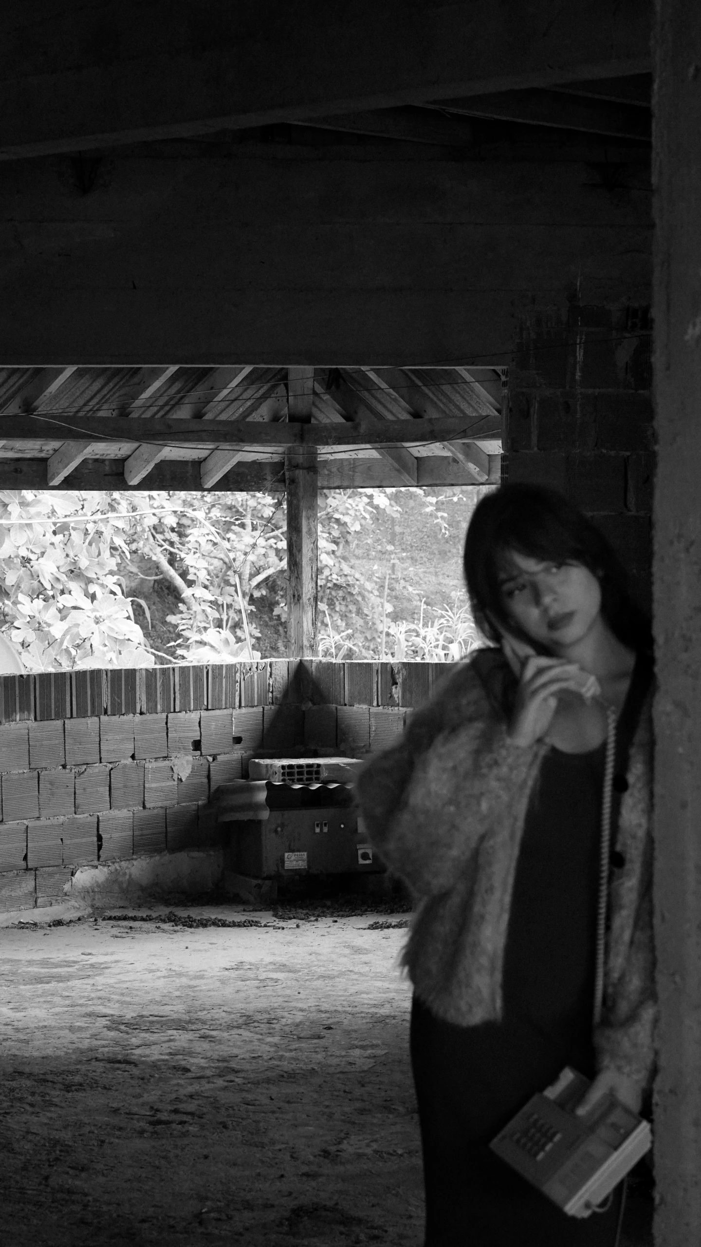 a woman standing in a barn holding a phone