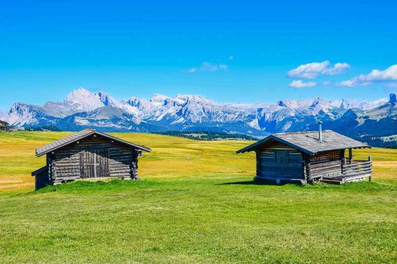 two small cabins are near one another in the mountains