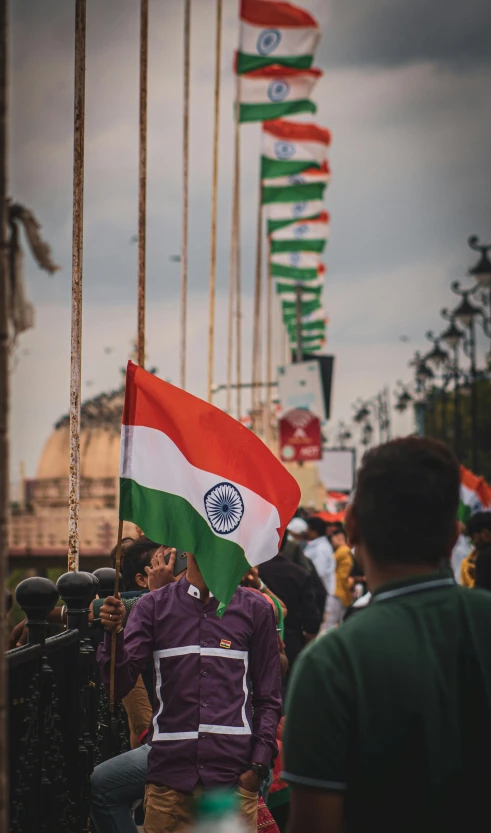 an indian man holding a flag in front of other people