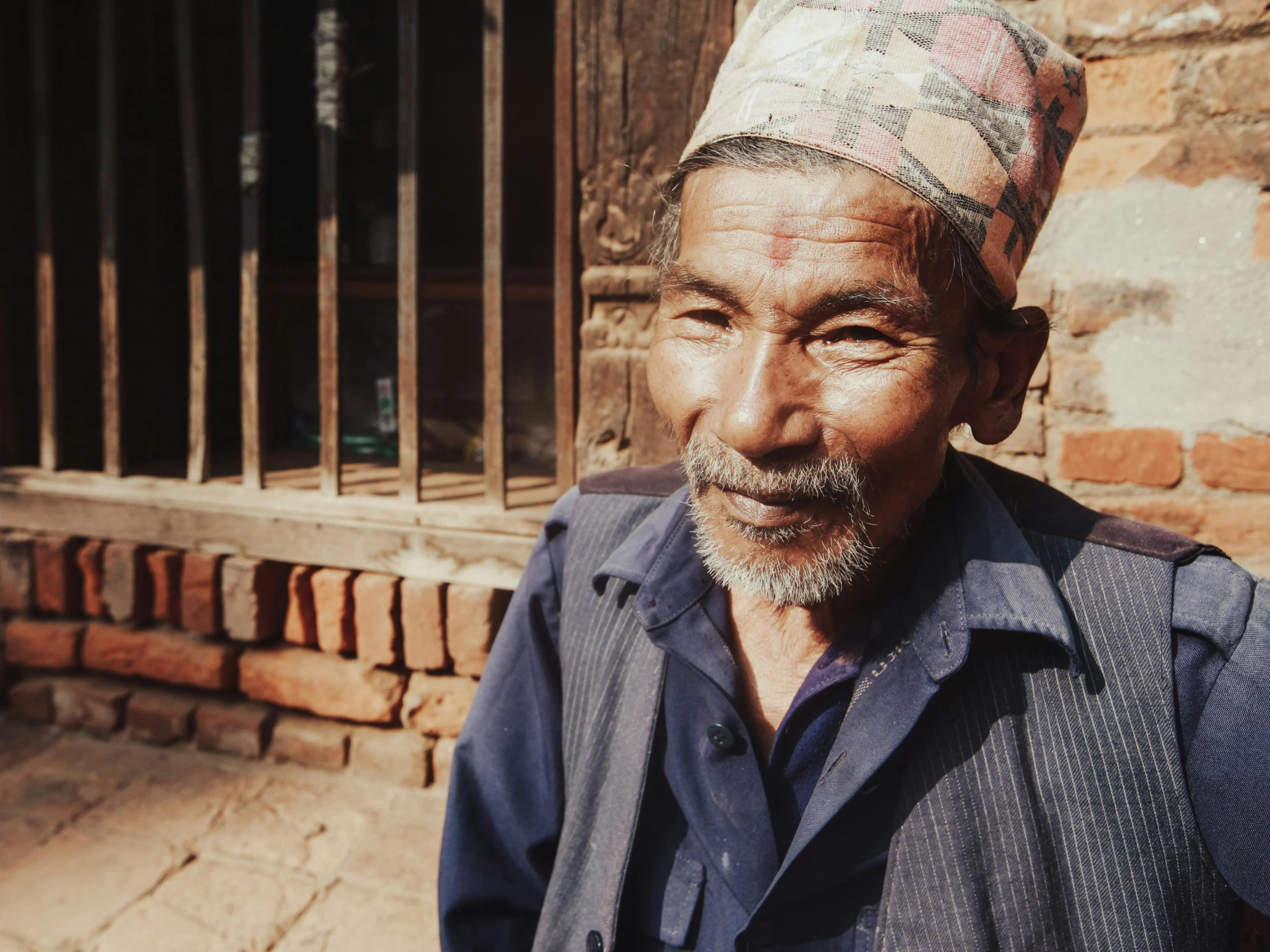 an old man with a turban poses for a po