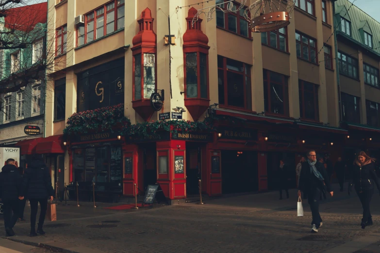 people are standing on the sidewalk outside an old building