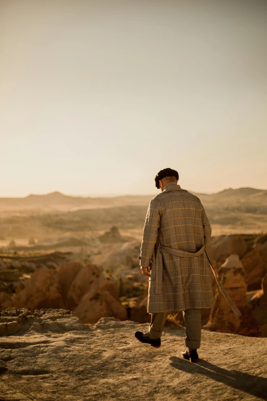 a man standing on top of a hill next to the sun