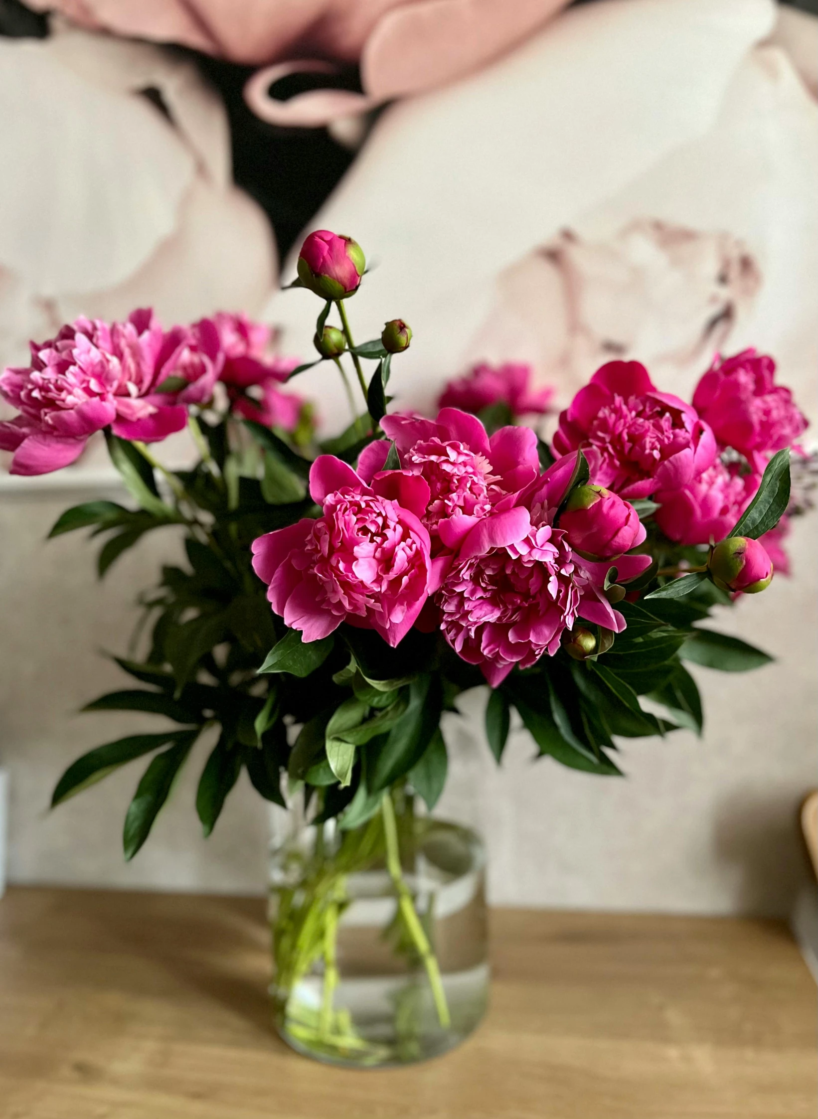 a glass vase filled with pink flowers on top of a table