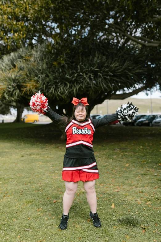 a  dressed in cheerleader gear while holding onto her cheer sword