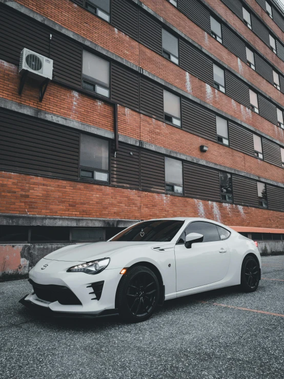 a white car in front of an apartment building