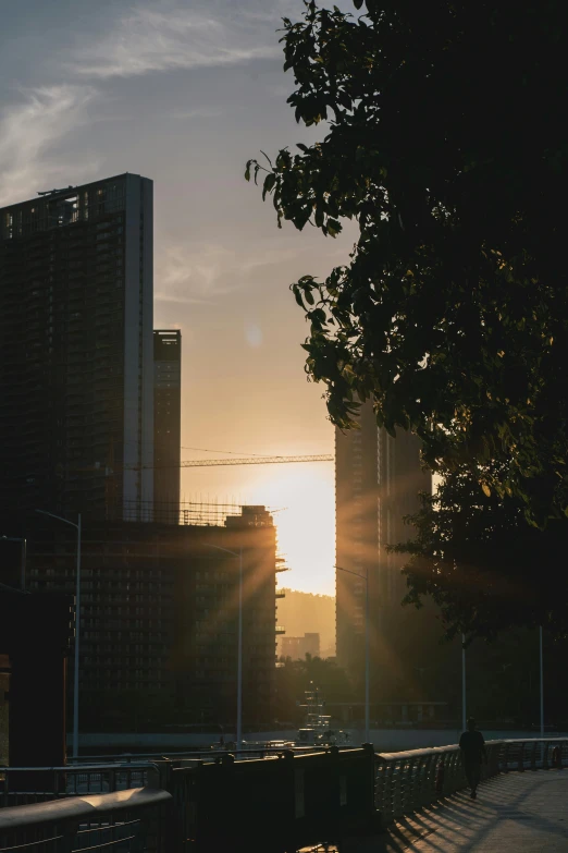 a very nice sun setting behind some very big buildings