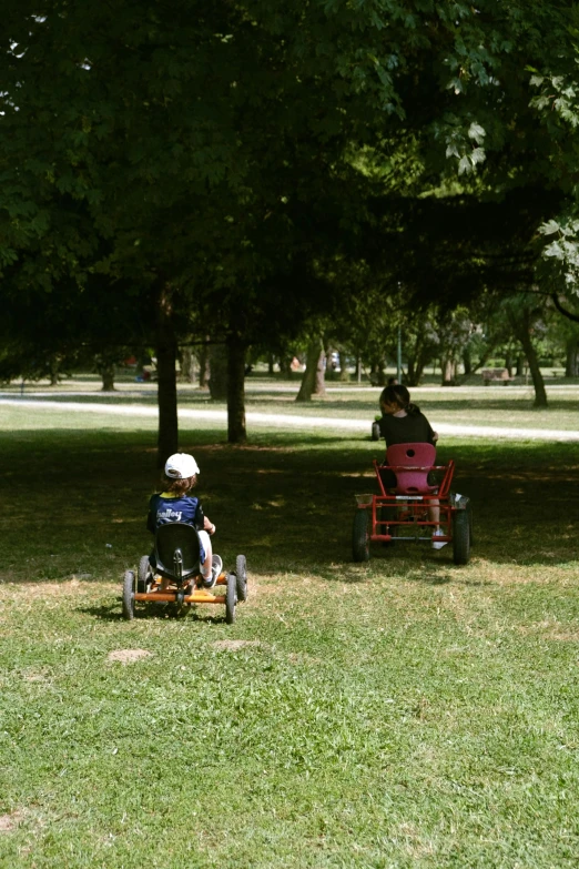 a child on a toy truck near an older red chair