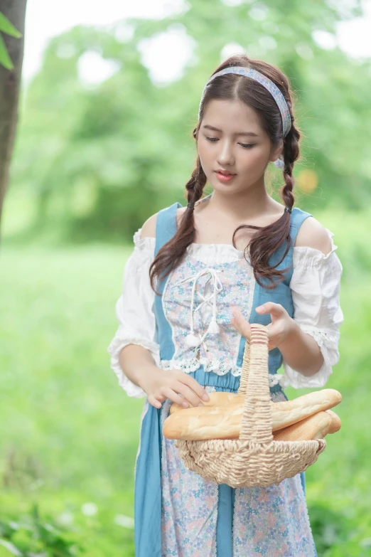 young asian girl in dress standing with basket and bread