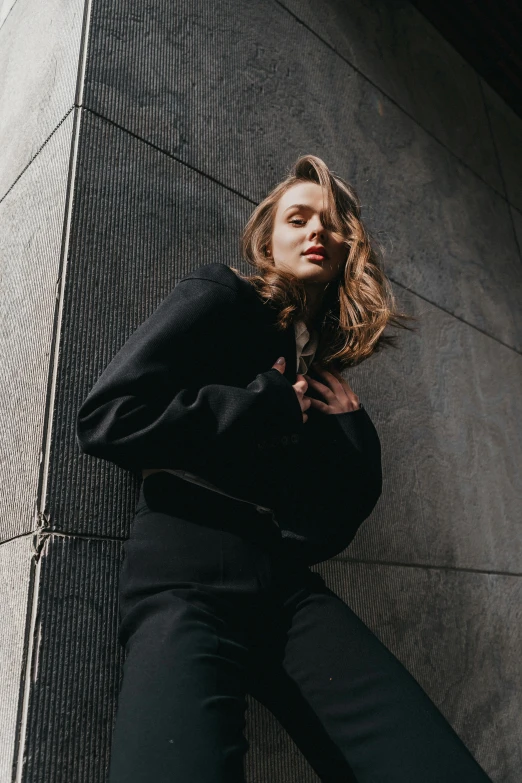 a person leaning up against a wall posing for a po