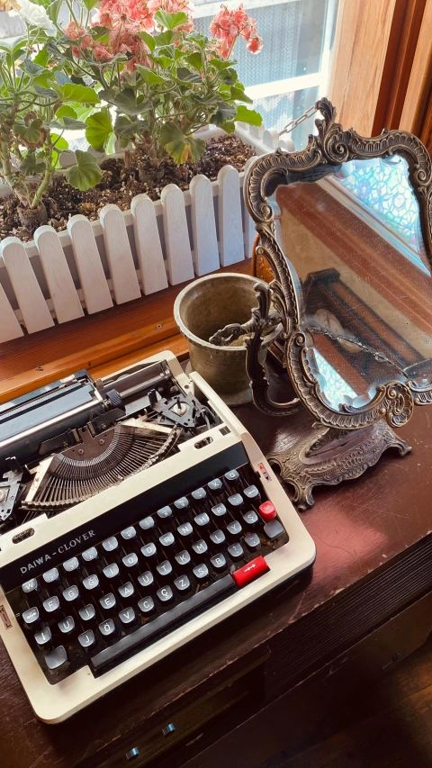 an old fashioned typewriter on a table with a mirror next to it