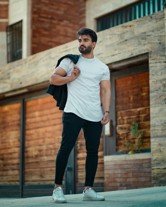 a man standing on the street holding onto his jacket