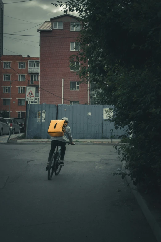 a person on a bicycle holding a yellow bag