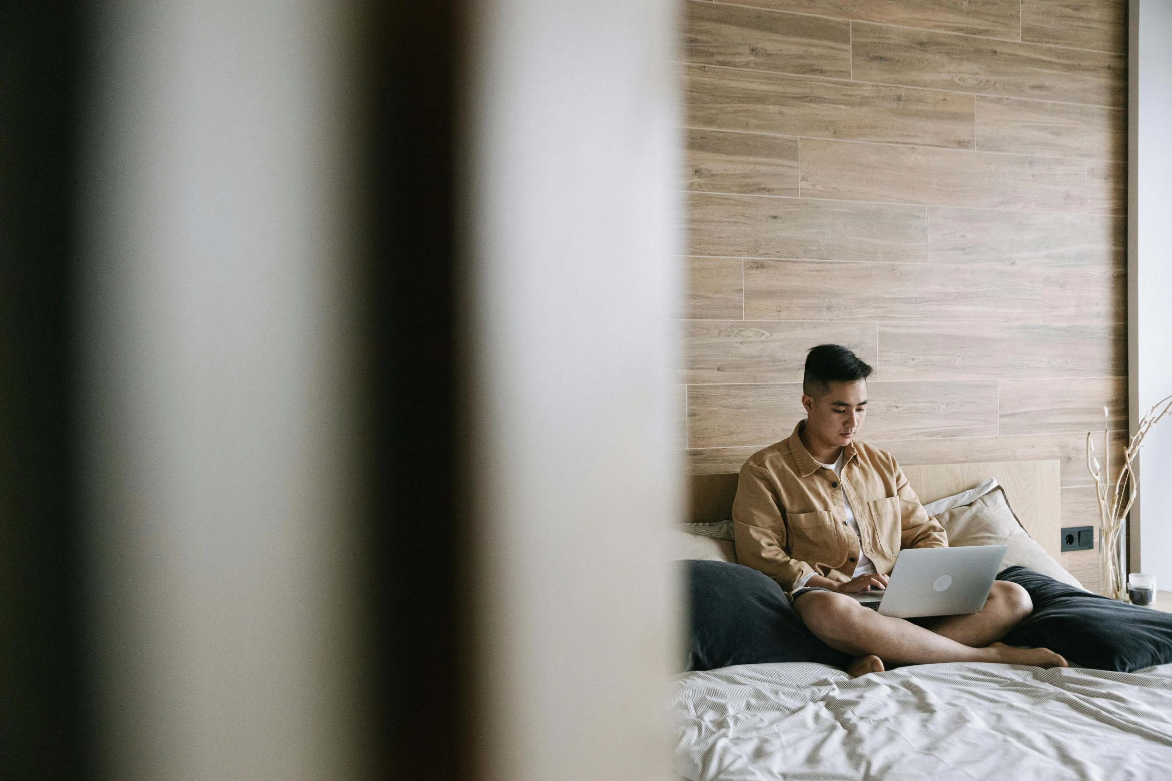 a man sitting on top of a bed holding a white book