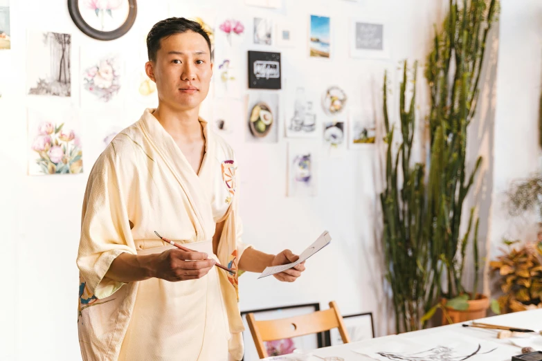 a man wearing a robe standing in front of a table