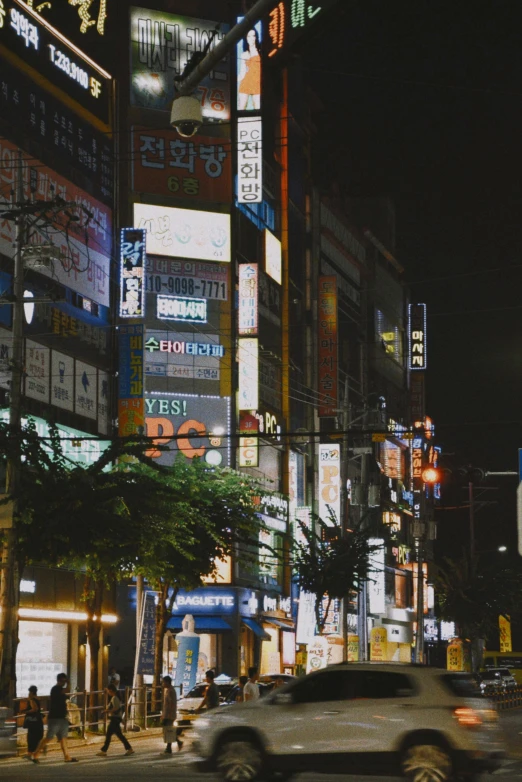 the cityscape shows people walking and cars driving down the street