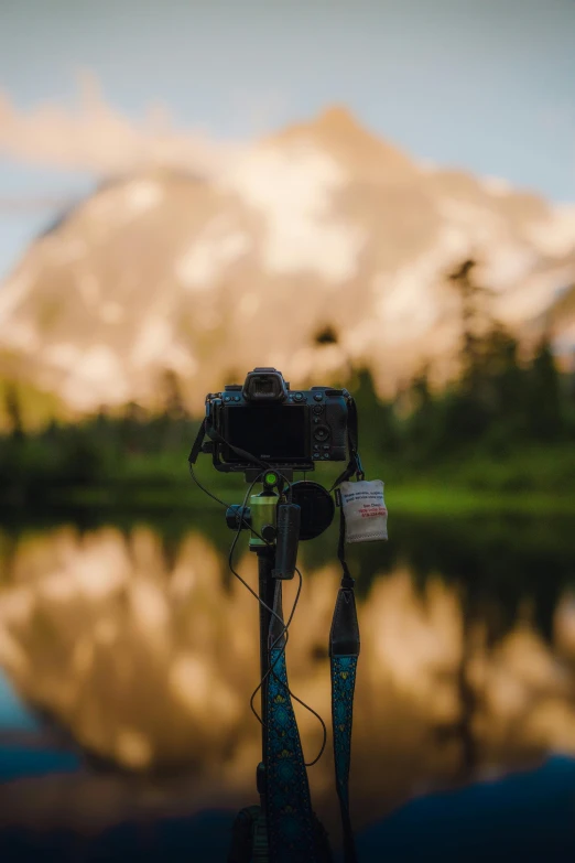 the camera is attached to a tripod in front of a lake