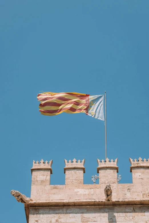 a flag and a building with a sky background