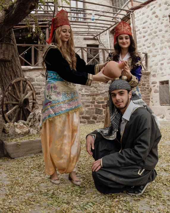 some young people in traditional dress with some trees