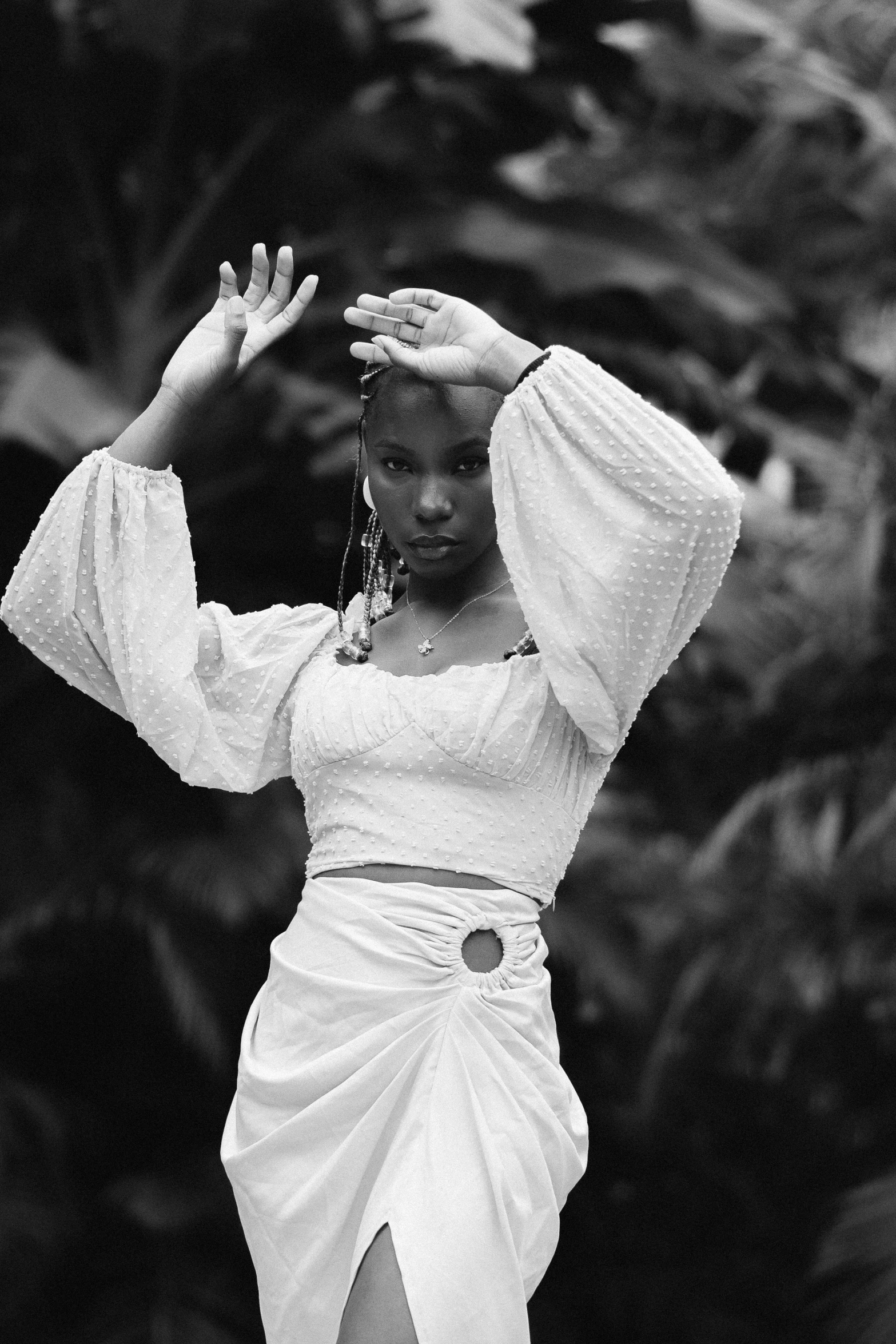 a woman wearing a white outfit and holding her hand up