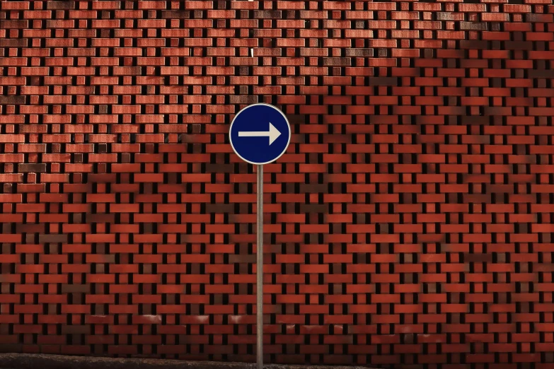 a blue street sign next to brick wall