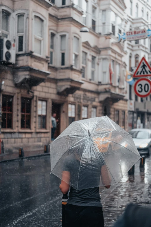 a woman is walking down the street with an umbrella