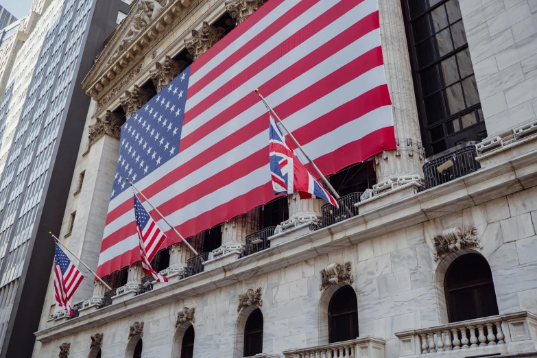 an american and british flag hanging from a building