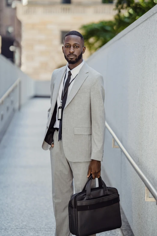 a man in a suit holding a briefcase by some stairs