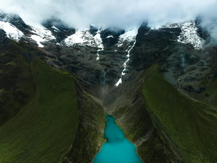 the mountains are covered in snow and green grass