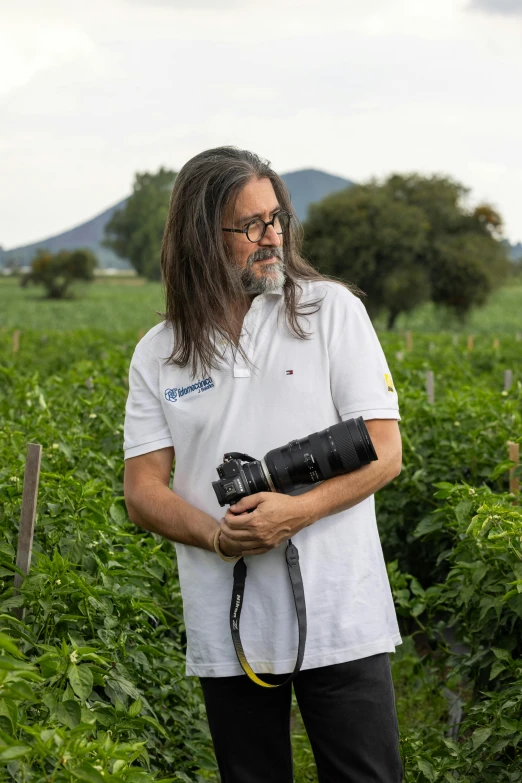 a man with a camera standing in the grass