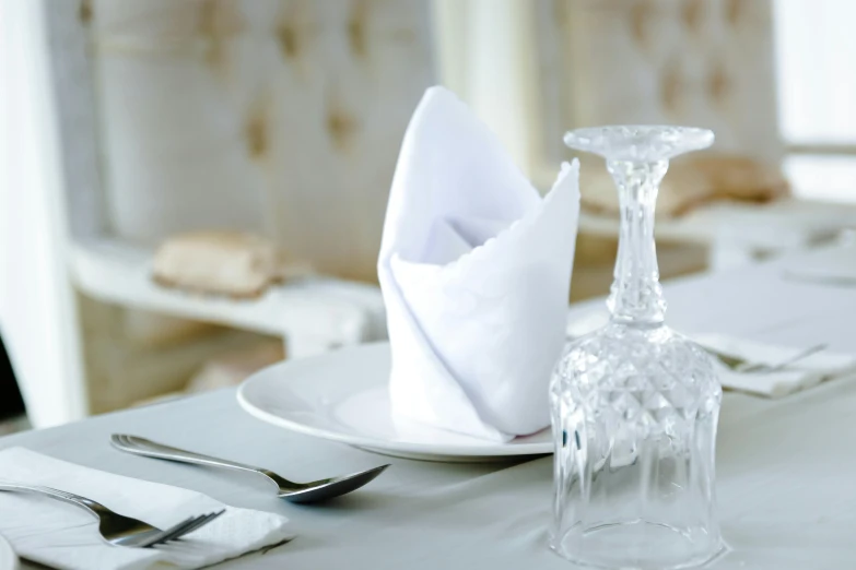 there are place settings with napkins, silverware and wine glasses