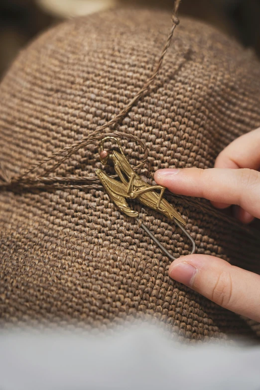 someone stitching soing onto a pillow with an old - fashioned gold needle