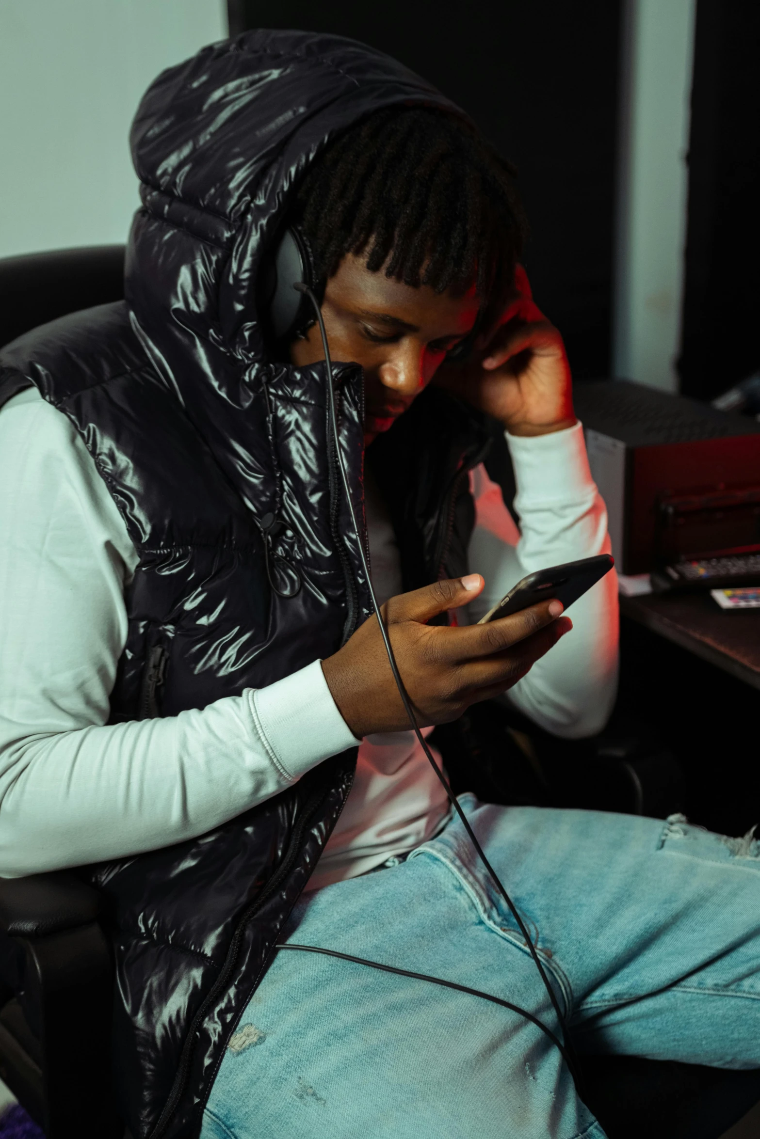 a man sitting on a chair while looking at his cellphone