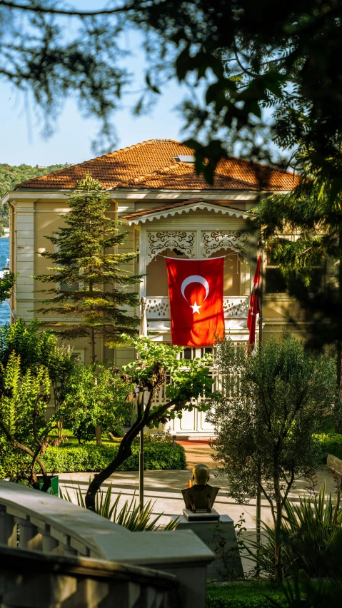 a house that is behind a fence with a flag