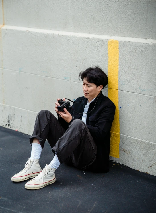 a person sitting in front of a wall with a camera