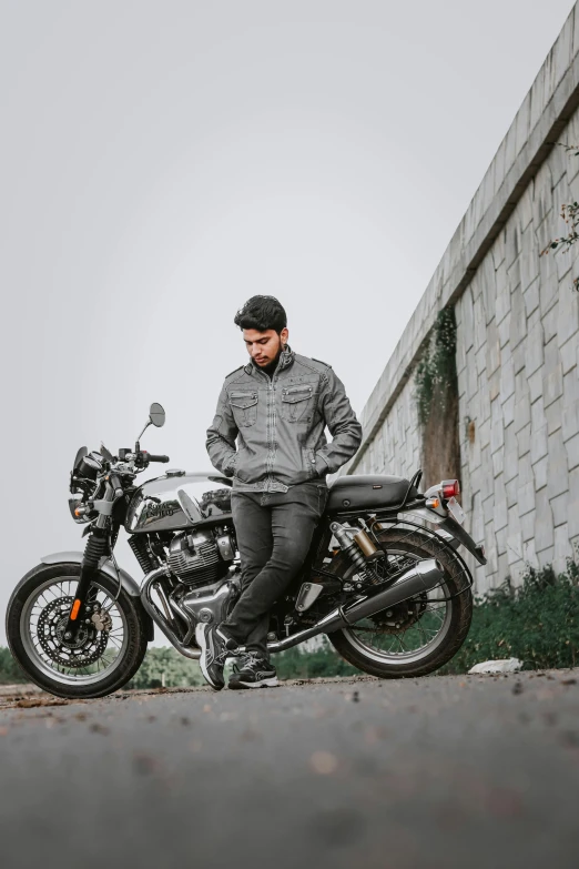 a man sitting on a parked motorcycle in the street