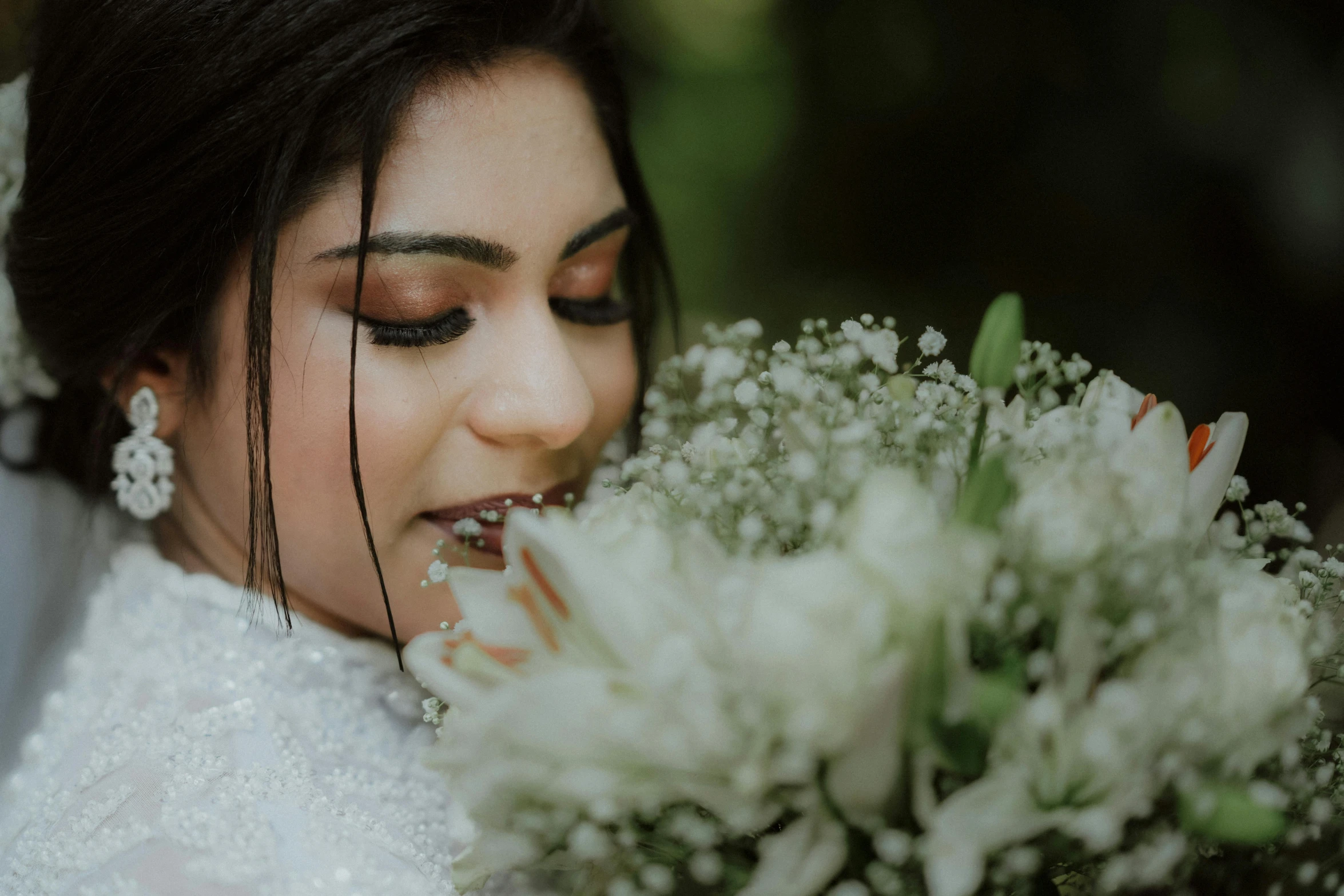 woman in wedding dress holding flowers near her face