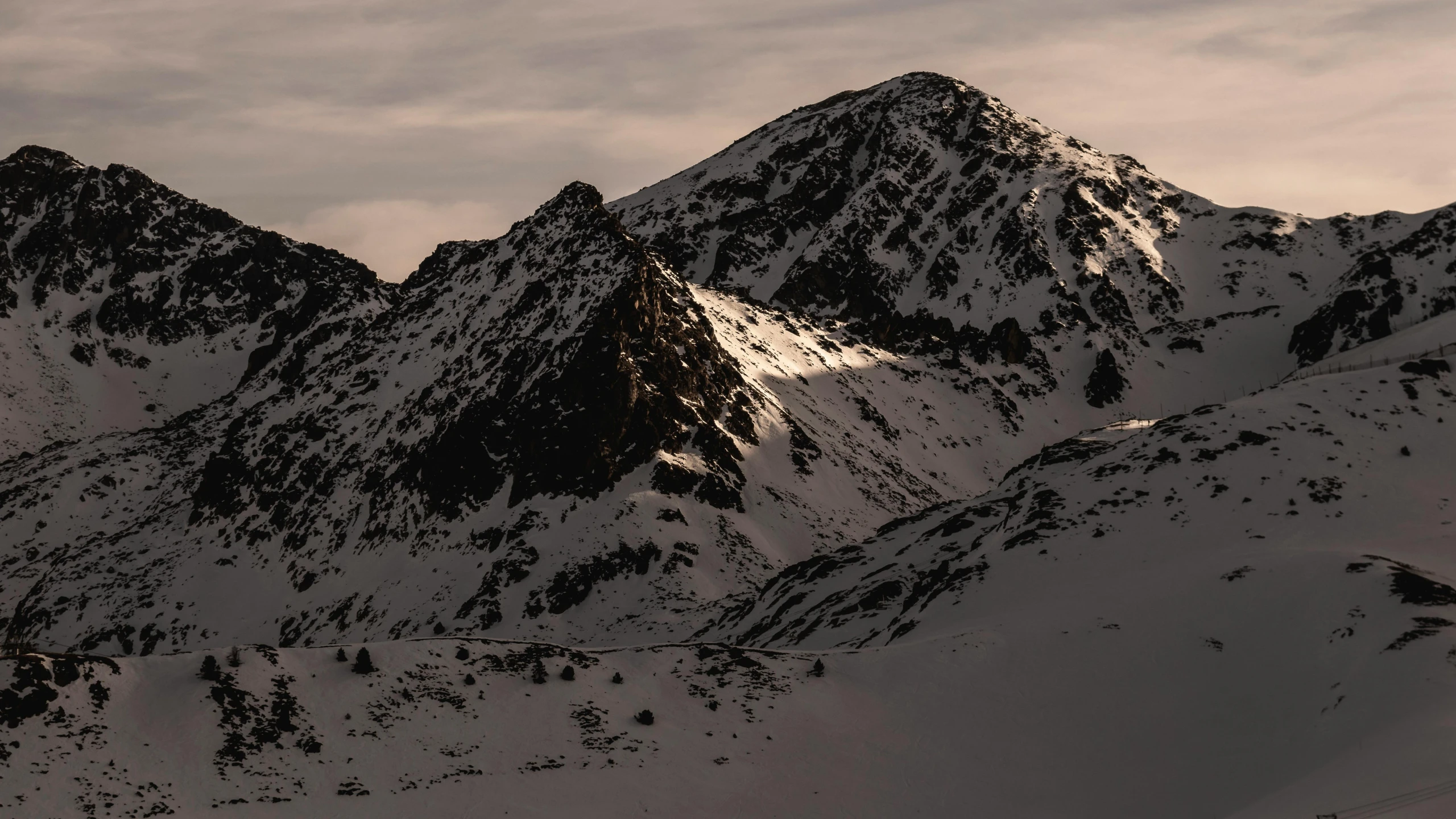 mountains covered with snow and some clouds in the background